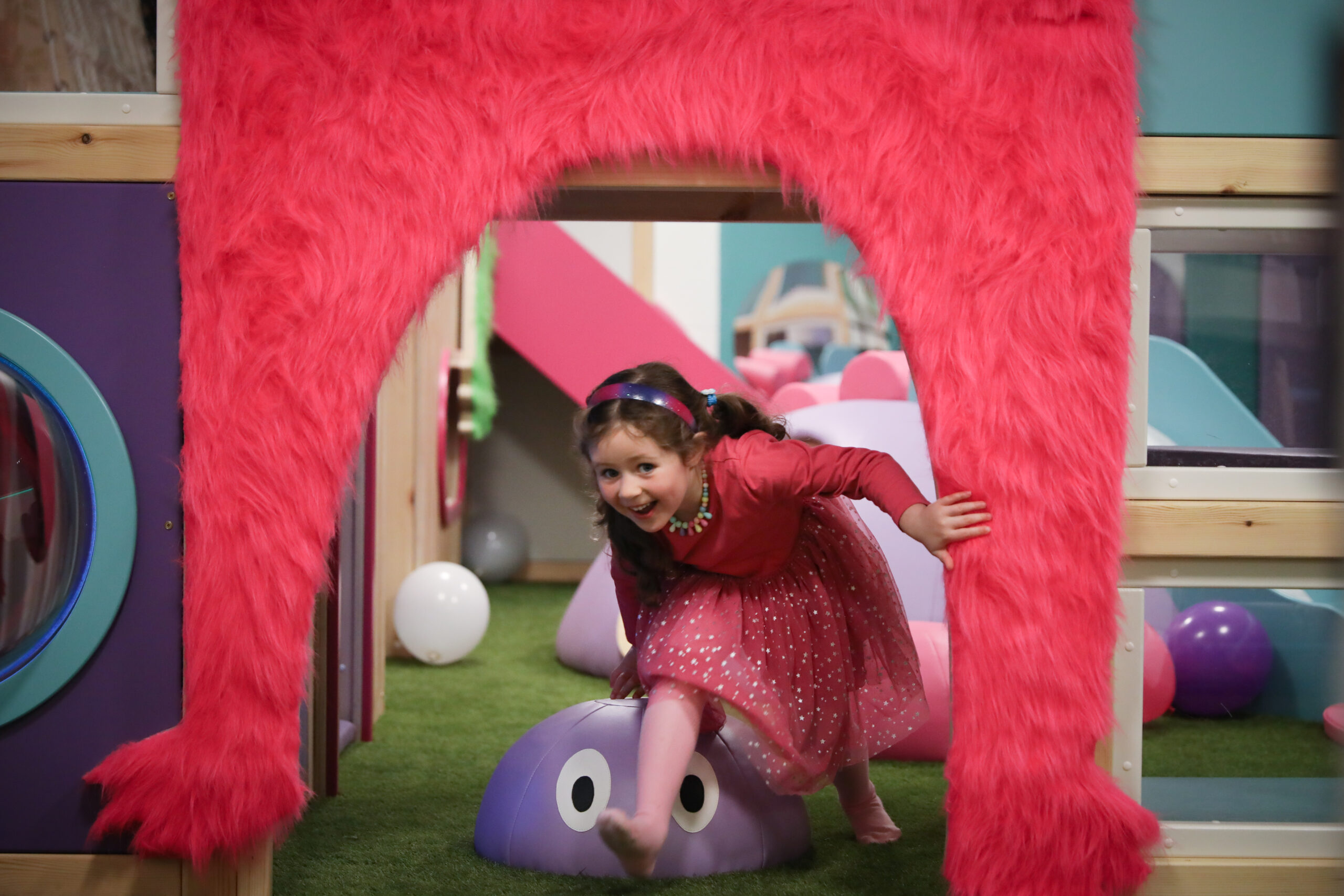 Toddler exploring tunnels and cargo nets on the Tiger Play frame